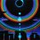 Eclipse Over Stonehenge is a uv (ultraviolet) blacklight fluorescent and glow-in-the-dark phosphorescent afterglow psychedelic spiritual visionary fantasy fine art backdrop painting by symeon nostrakis of 333artworks/tripleviewart, and depicting a mystery tribal party of pixies/elf/elves/goblins dance on magic psylocybin mushrooms growing form the earth in stonehenge landscape, and a double circular rainbow and stars around a total eclipse (available on posters, postcards, t-shirts, backdrops/banners)